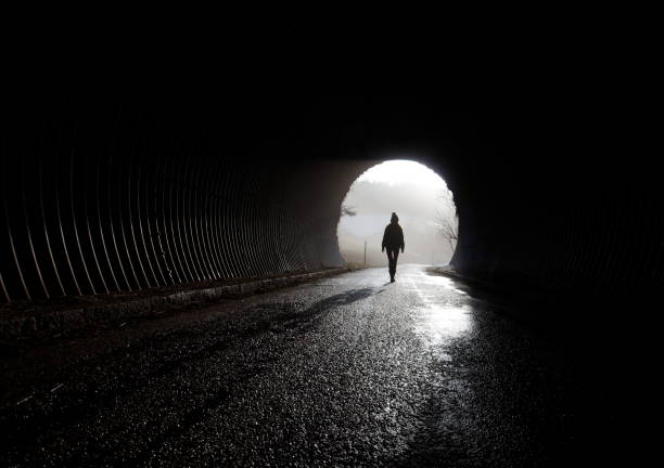 lonely silhouette walking trough darkness, depression